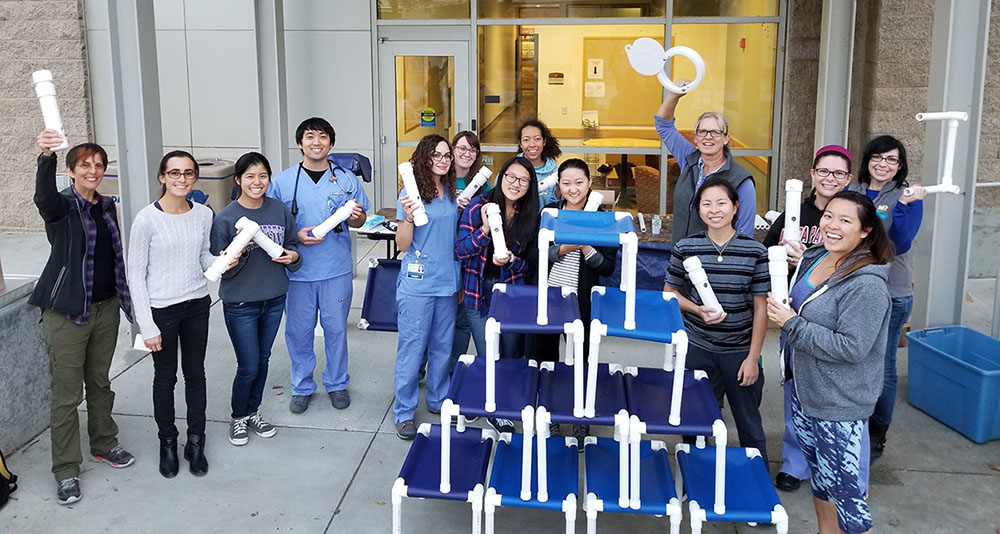 Shelter Medicine club students show off the beds and toys they created using white PVC pipe and blue vinyl