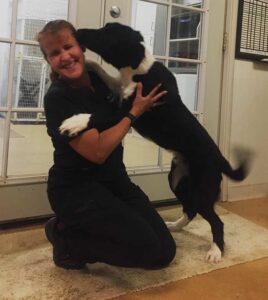 A friendly black & white dog licks Dr. Delany's face